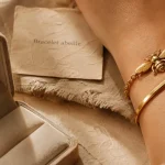 Bracelet abeille en acier doré et jonc minimaliste sur poignet